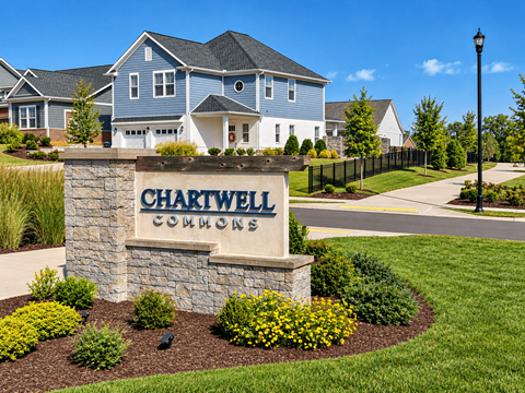 A sign for Chartwell Commons in front of a house.