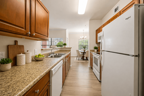 A kitchen with a white fridge and wooden cabinets.