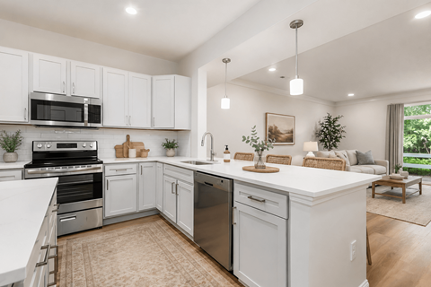 A modern kitchen with white cabinets and stainless steel appliances.