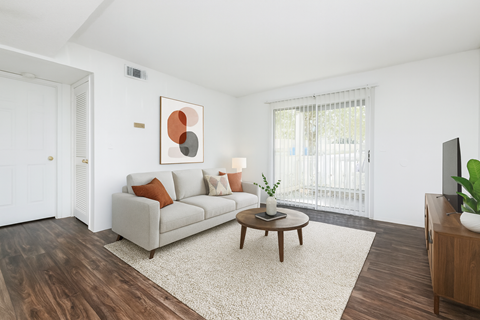 A living room with a white couch, a brown coffee table, and a painting on the wall.