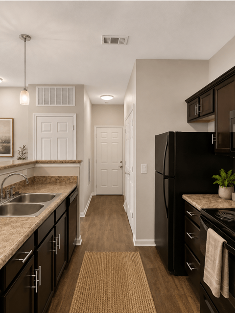 A kitchen with black cabinets and a black refrigerator.