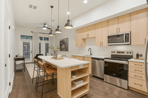 A modern kitchen with wooden cabinets and stainless steel appliances.