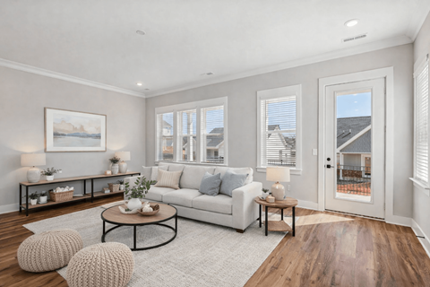 A living room with a white couch, a coffee table, and a painting on the wall.