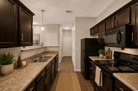 A kitchen with dark brown cabinets and a white door in the background.