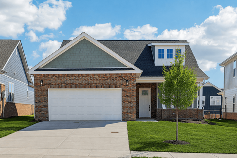 A house with a white garage door and a brick facade.