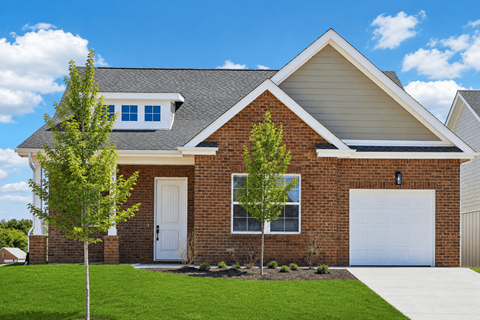 A house with a white garage door and a brick facade.