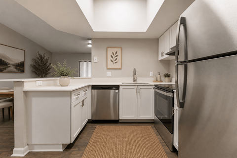 A modern kitchen with white cabinets and stainless steel appliances.