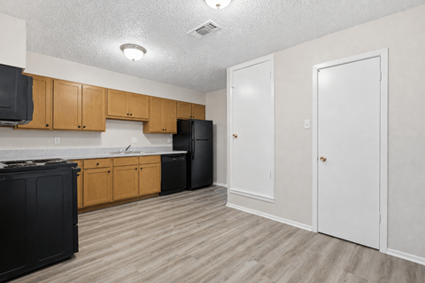 A kitchen with black appliances and wooden cabinets.