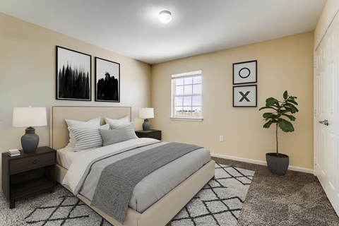 A bedroom with a bed, nightstands, and a plant.