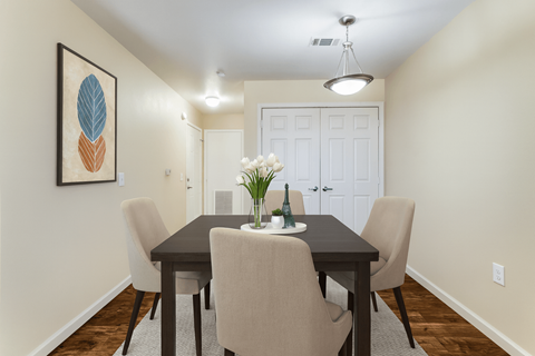 A dining room with a table and chairs.
