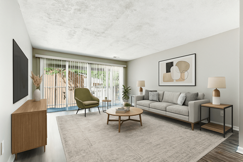 A living room with a grey couch, a green chair, a wooden cabinet, and a painting on the wall.