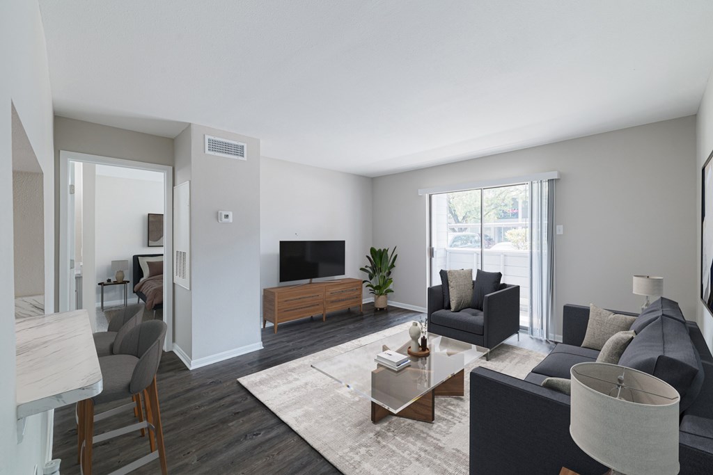 A living room with a grey couch, a coffee table, and a television.
