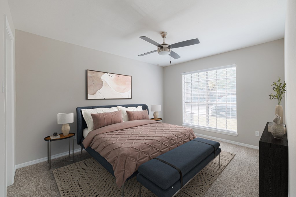 A bedroom with a bed, nightstand, and a painting on the wall.