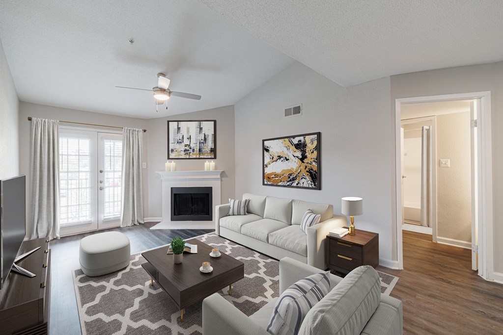 A living room with a fireplace, a grey couch, and a painting on the wall.