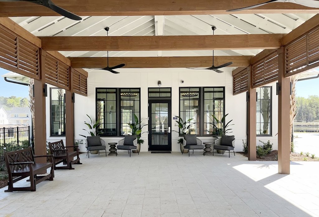 A patio with a white floor and wooden pillars.