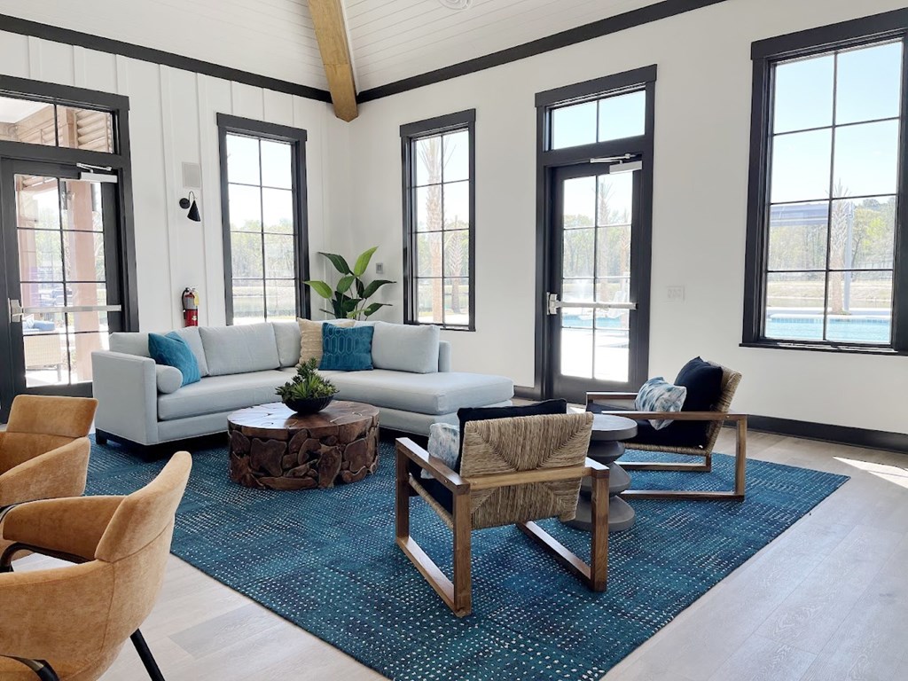 A living room with a white couch, a wooden coffee table, and a rug.