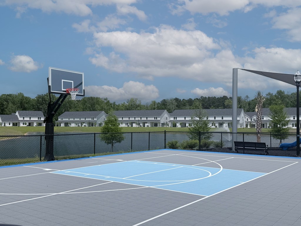 A basketball court with a hoop and a fence.
