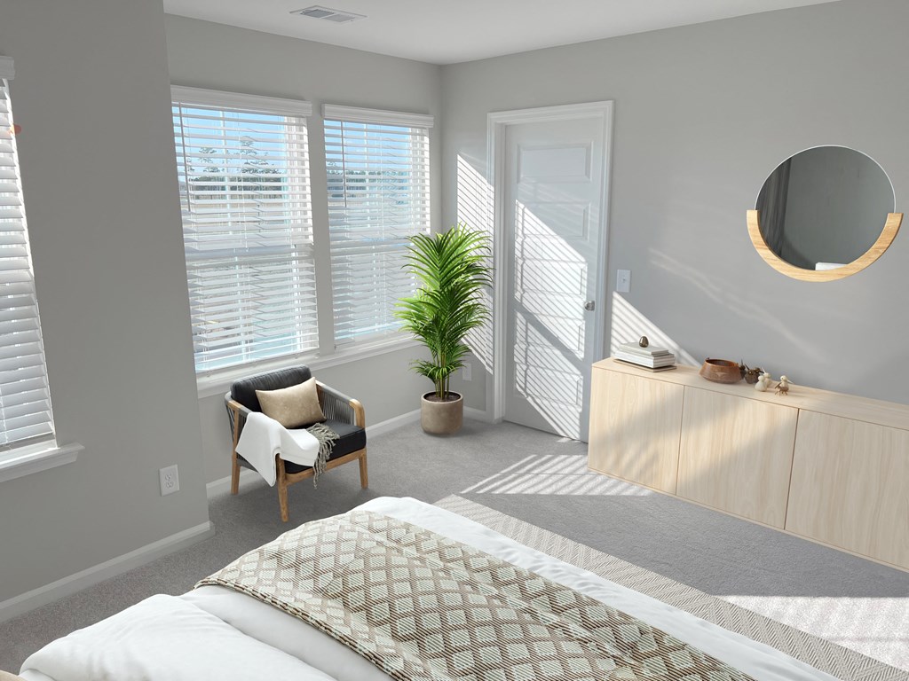 A bedroom with a bed, chair, and mirror.