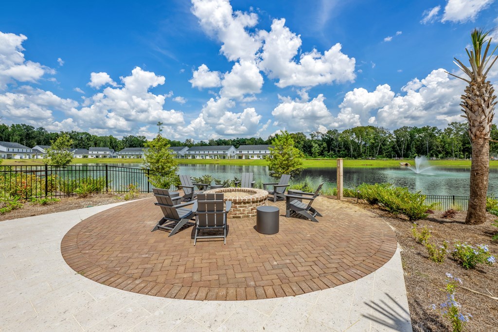 A patio with a table and chairs overlooking a body of water.