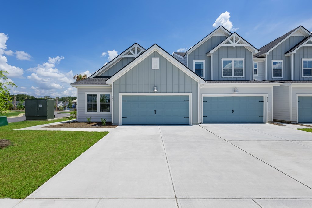 A large house with a grey roof and two garages.
