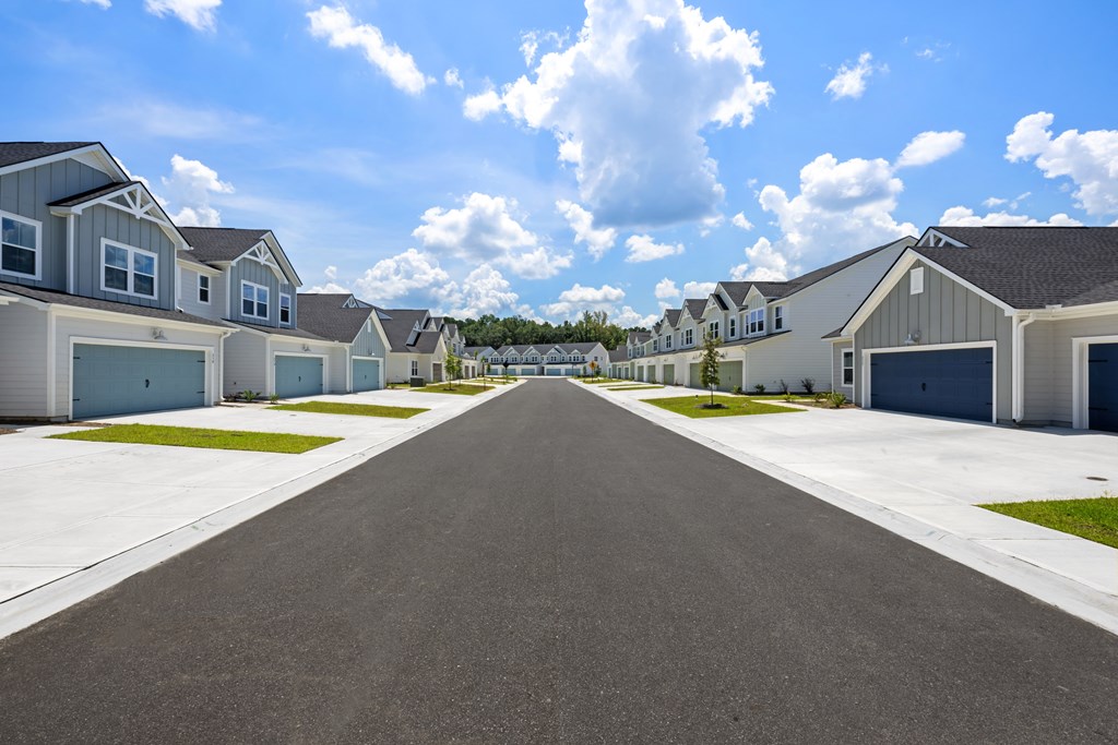 A long, straight road leads the eye through a residential neighborhood.