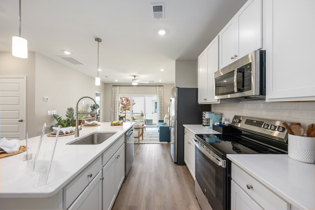 A modern kitchen with white cabinets and stainless steel appliances.