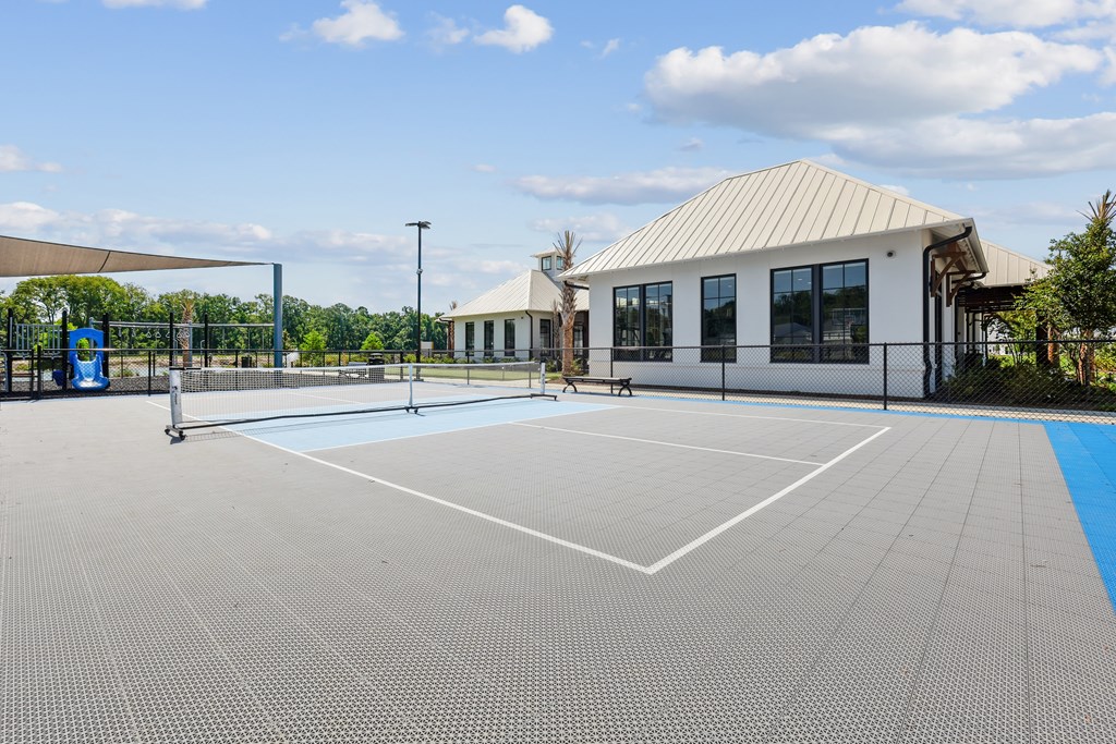 A tennis court with a building in the background.