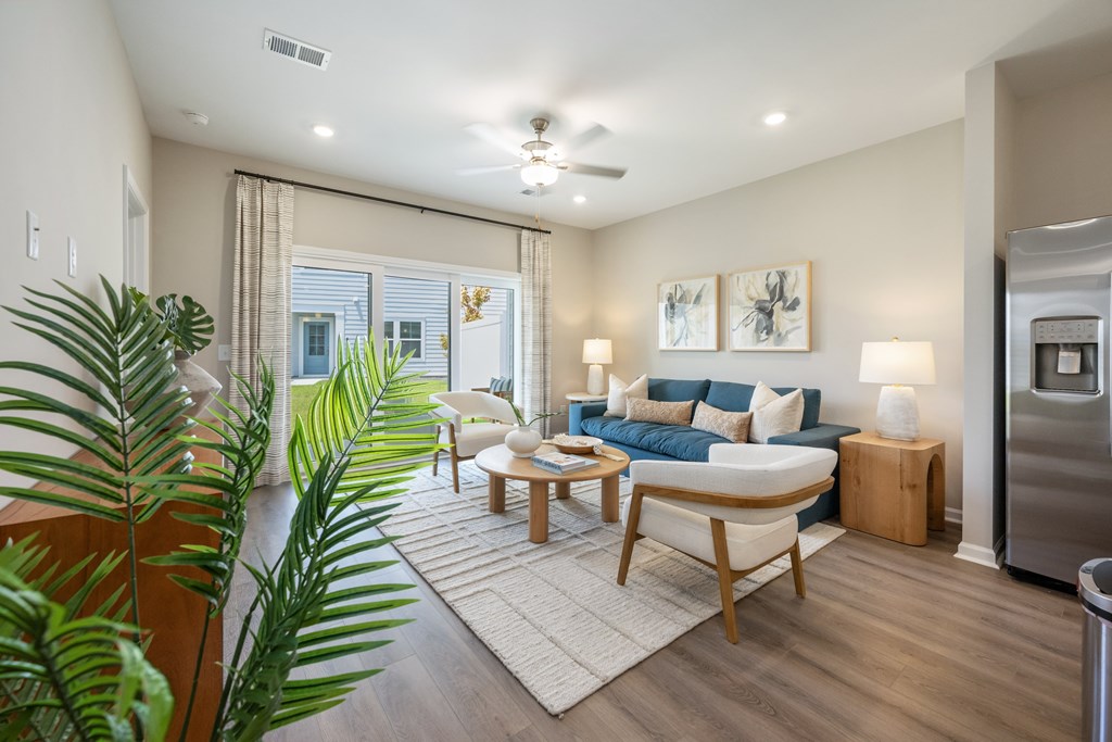 A living room with a blue couch and a wooden coffee table.