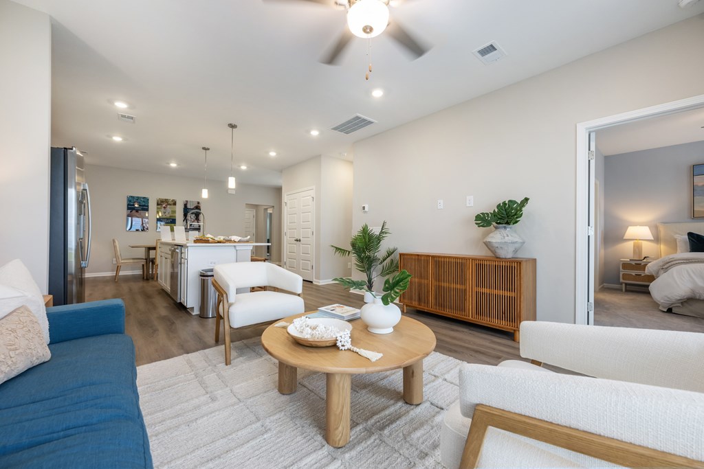 A living room with a blue couch, a wooden coffee table, and a ceiling fan.