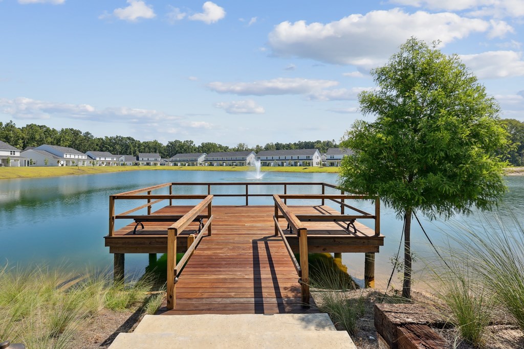 A wooden dock extends into a blue body of water.