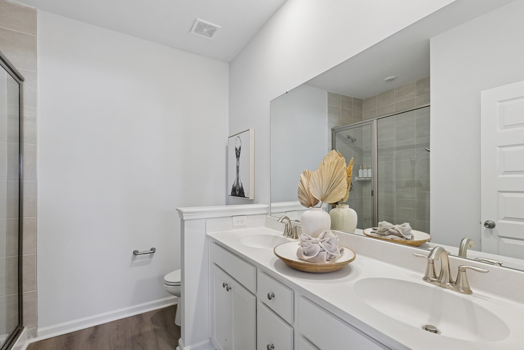 A white bathroom with a white sink and a white toilet.