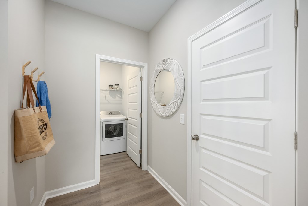 A white door with a round mirror on the wall.