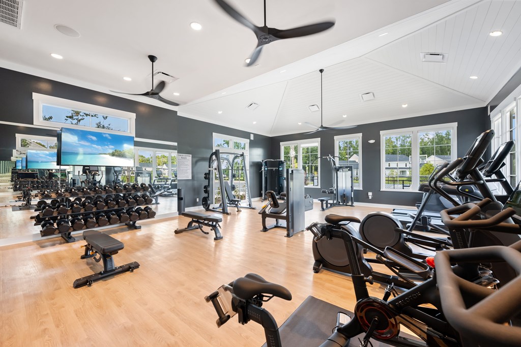 A gym with a variety of equipment including treadmills, stationary bikes, and weight machines.