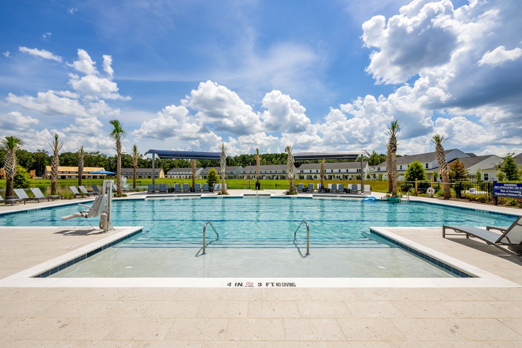A large outdoor swimming pool with a sign that reads "4 IN. FT SWIMMING".