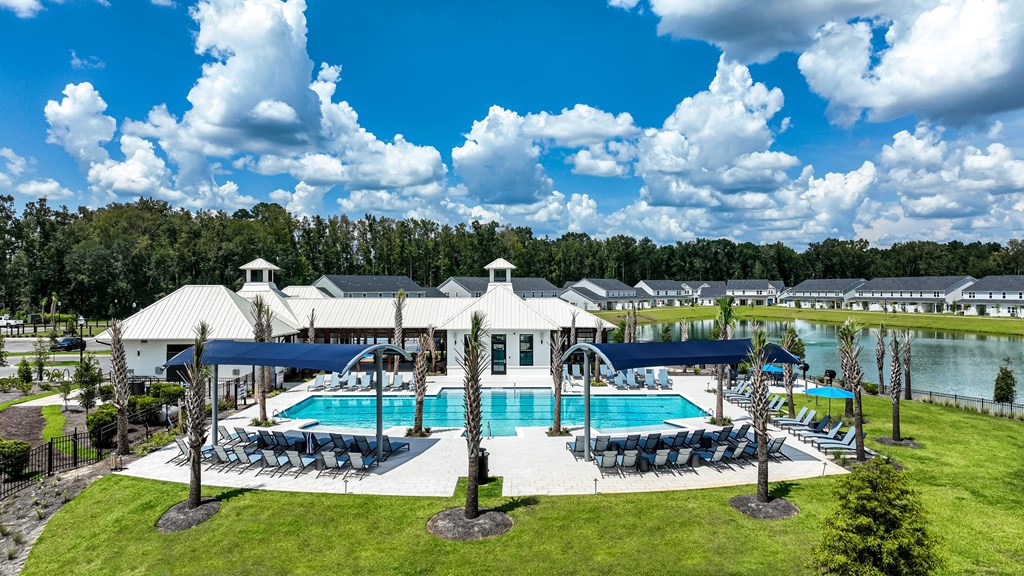 A large white building with a pool in front of it.