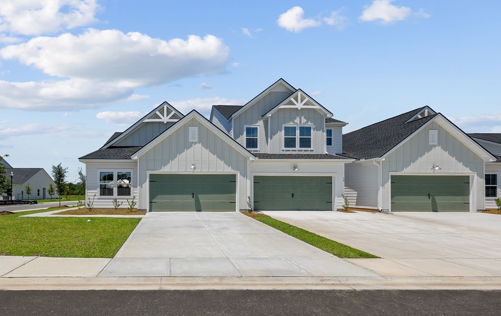 A large, modern house with a grey roof and white walls.