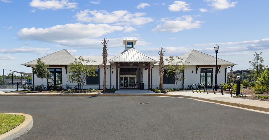 A white building with a grey roof and a blue sign on top.