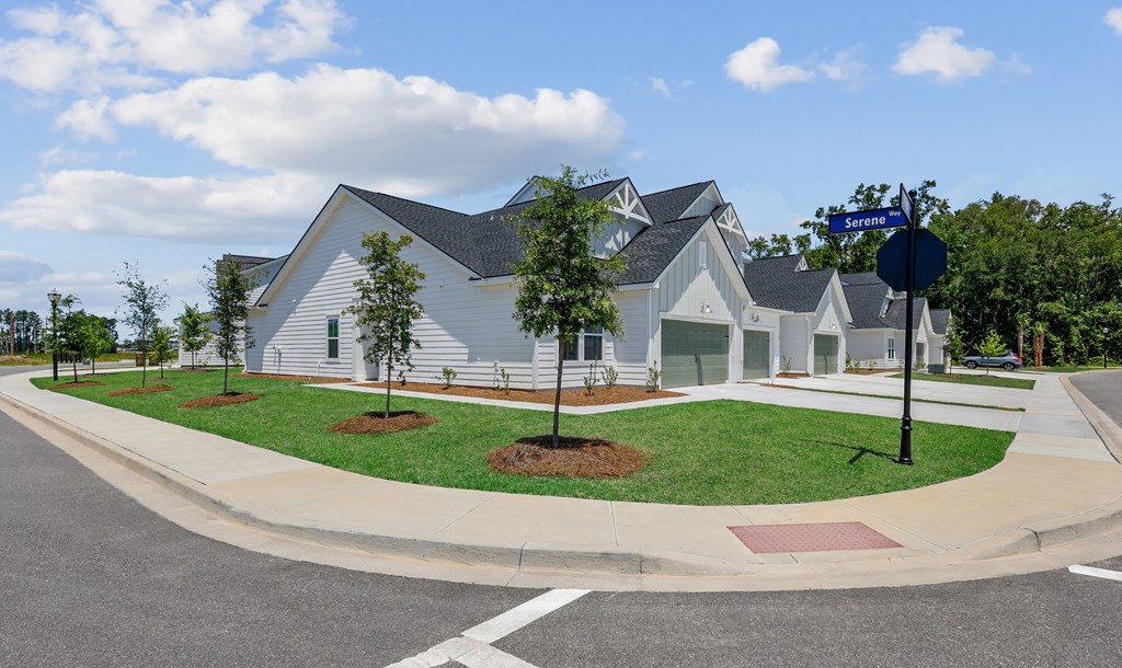 A street view of a residential area with houses and a street sign.