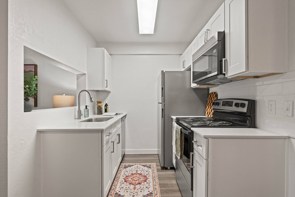 A kitchen with white cabinets and a black stove top oven.