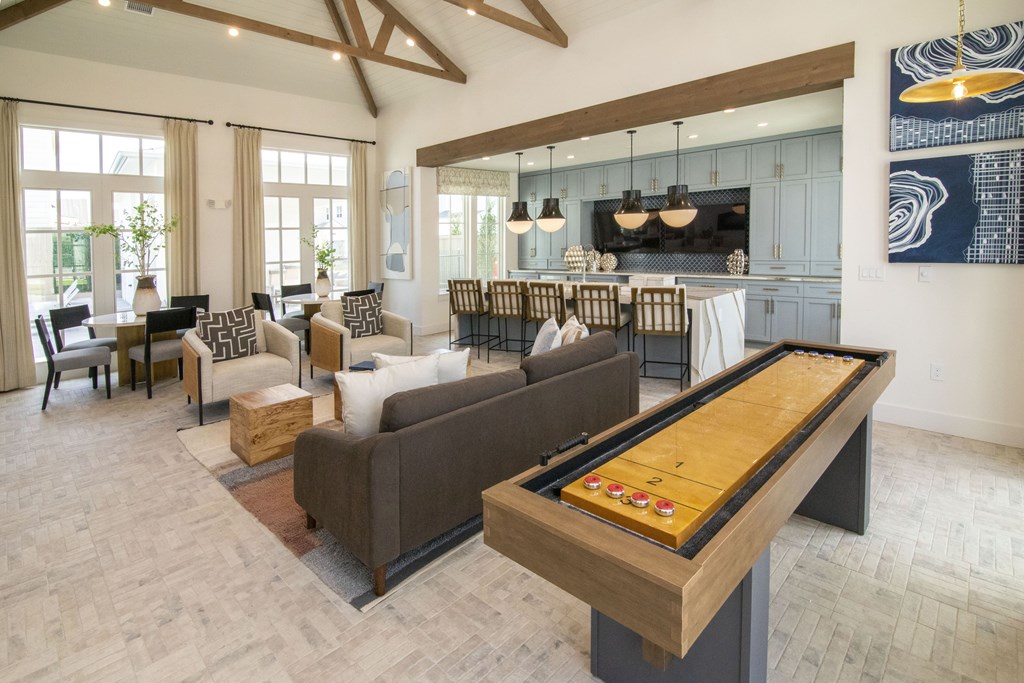 A billiard table is in the middle of a living room with a couch and chairs.