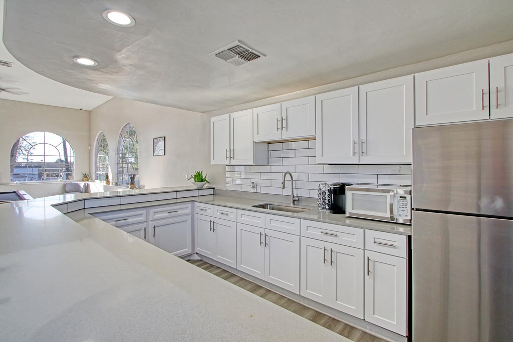 a kitchen with white cabinets and stainless steel appliances