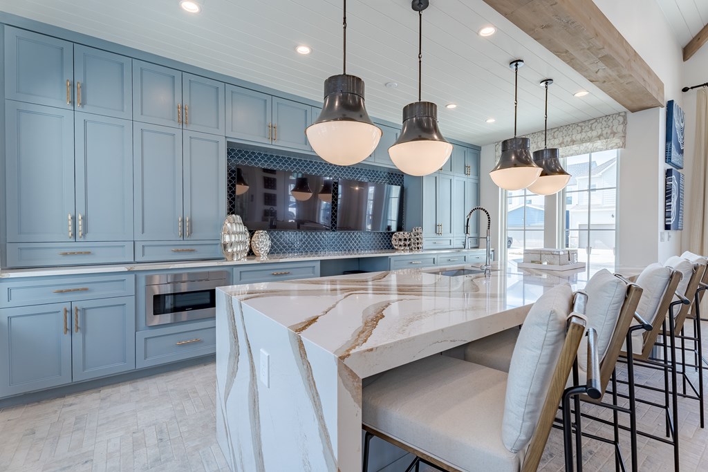 A kitchen with a marble countertop and a large island.