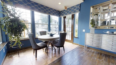 A dining room with a table and chairs.