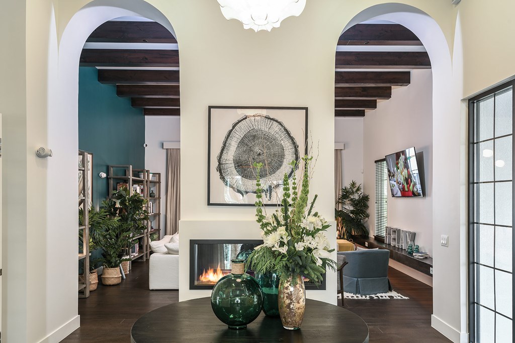 A living room with a fireplace and a large painting above it.
