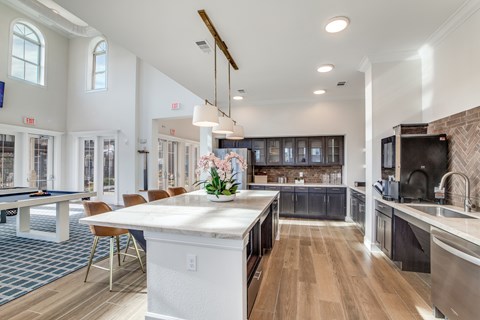 A kitchen with a pool table and a dining table.