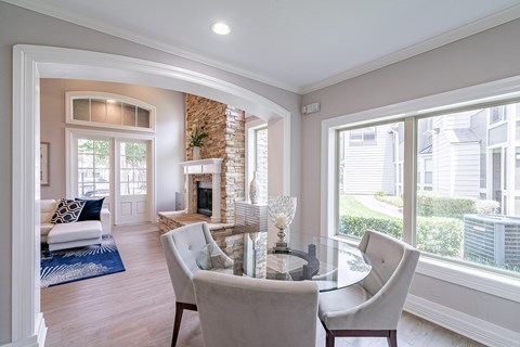A modern dining room with a glass table and chairs.