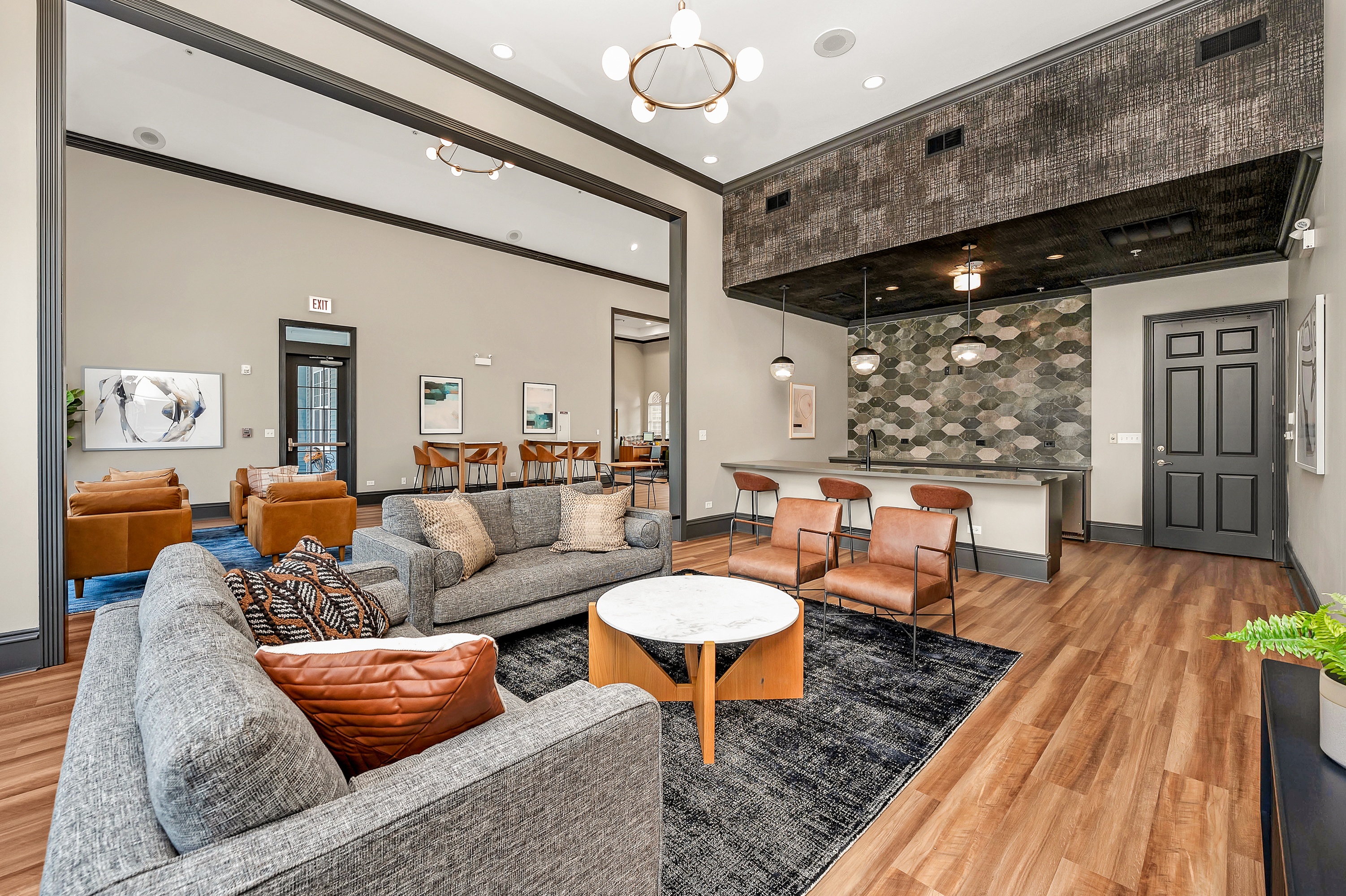 A living room with a grey couch, orange pillows, and a wooden coffee table.