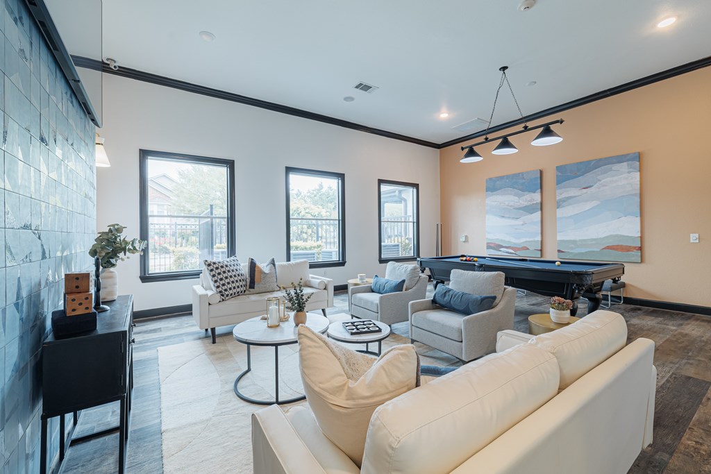 A living room with a pool table and a fireplace.