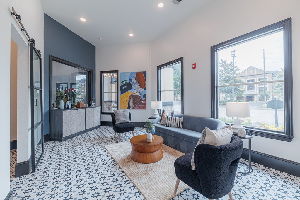 A living room with a black chair and a patterned floor.