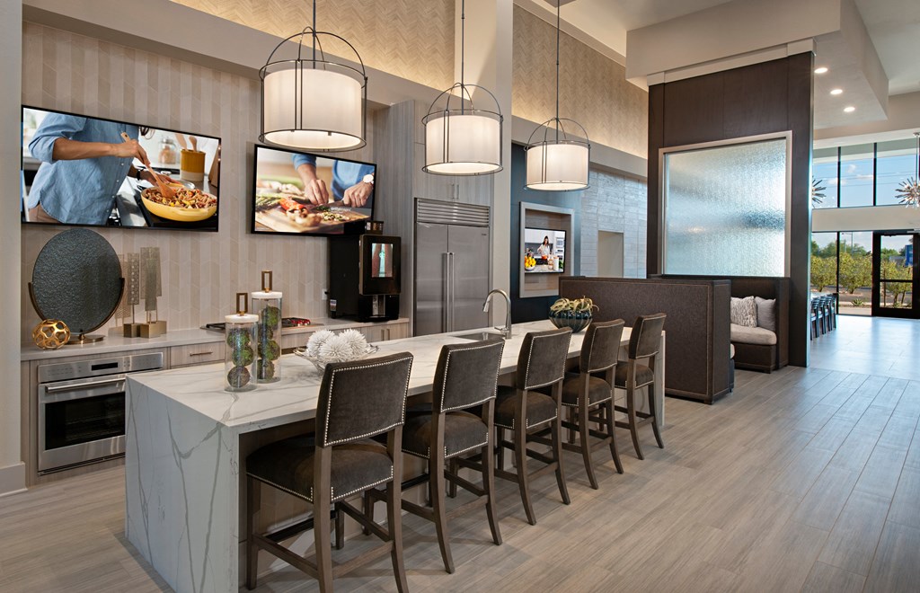 a kitchen with a marble counter top and a bar with chairs
